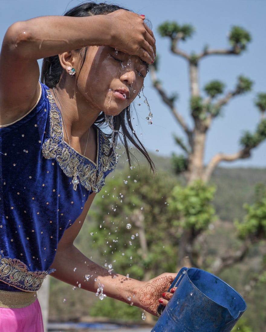 Nepalese girl washing her face with water